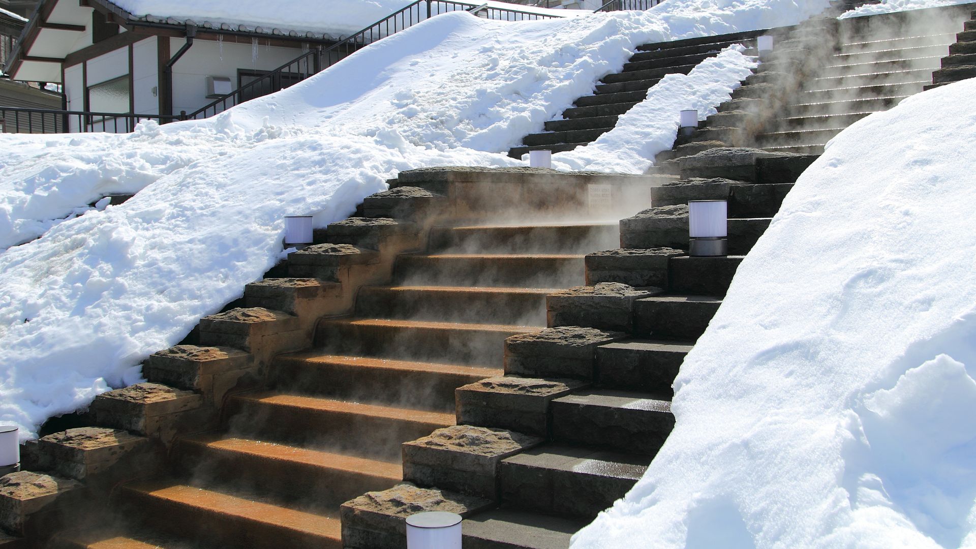 Gros plan des escaliers d'Ikaho Onsen partiellement déneigés par les sources chaudes